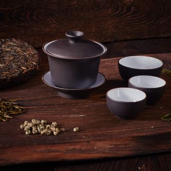 Ceramic tea cup, loose tea leaf on wood table