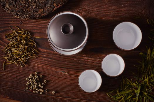 Ceramic tea cup, loose tea leaf on wood table