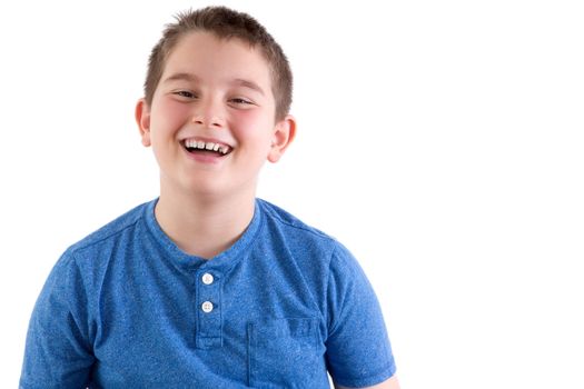 Carefree attractive young boy enjoying a good joke standing laughing at the camera, head and shoulders portrait isolated on white with copyspace