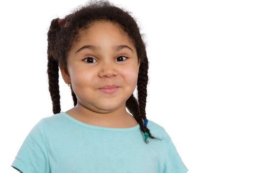 Cute little African American girl with her curly hair in braids looking at the camera with a sweet impish smile, head and shoulders on white with copyspace