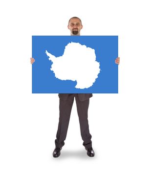 Smiling businessman holding a big card, flag of Antarctica, isolated on white