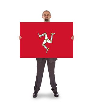 Smiling businessman holding a big card, flag of Isle of Man, isolated on white