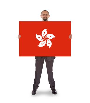 Smiling businessman holding a big card, flag of Hong Kong, isolated on white