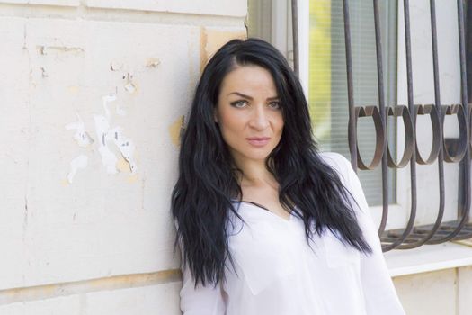 European young brunette on background white wall