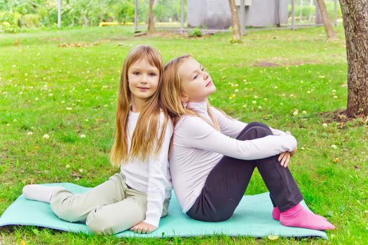 Photo of two girls sitting on grass in summer