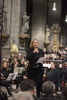 FRANCE, Paris: Danielle Simonnet speaks one week following the terrorist attacks at the symphony. Renowned French conductor Hugues Reiner led a 400-strong orchestra and choir in their performance of famous Mozart melodies on November 20, 2015.  Several thousand people attended the concert and collectively sang the French national anthem, the Marseillaise. Among the speakers at the event were the conductor Hugues Reiner, Danielle Simonnet representing the French government, and the catholic priest of Saint Sulpice church.  Performers included Joachim Bresson (tenor), Jacques Calatayud (baritone), Olga Gurkovska (alto) and Claudine Margely (soprano). Conductor Hugues Reiner called for solidarity and resistance against terrorism. 
