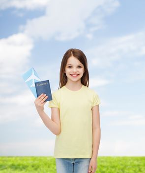 travel, holiday, vacation, childhood and transportation concept - smiling little girl with airplane ticket and passport