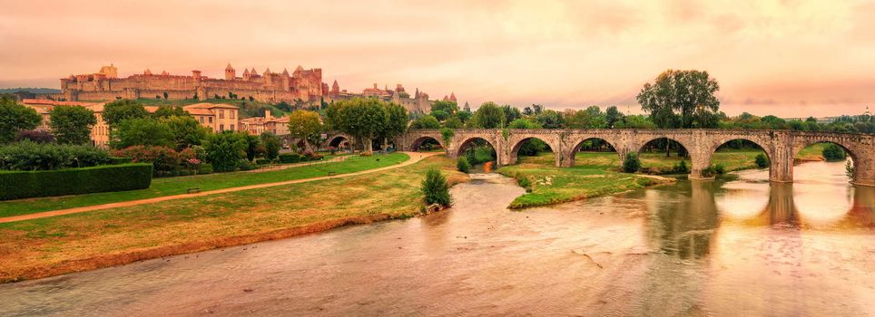 Sunset over the fortified city of Carcassonne and the Pont Vieux crossing the Aude river, France
