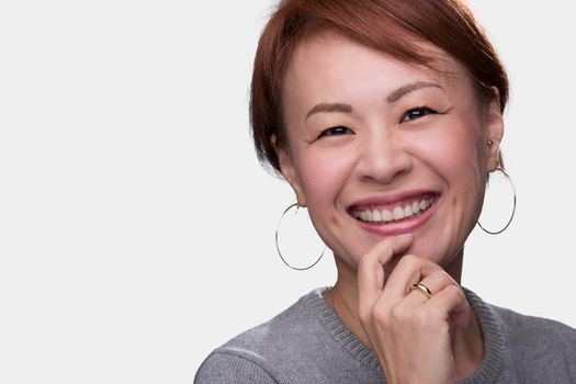 A headshot of a smiling middle aged Japanese woman on a white background.