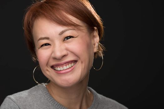 A headshot of a smiling middle aged Japanese woman.