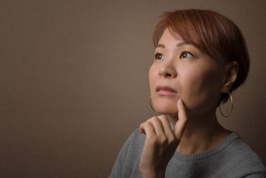 A headshot of a thoughtful middle aged Japanese woman.