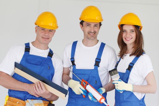 Group of construction workers in protective helmets with tools 