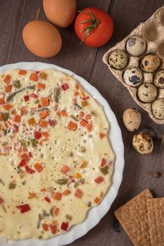 baked omelette with different eggs and vegetables with rye small load of bread