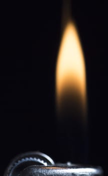 Lighter with Flame close up on black background.