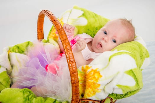 a two-month baby girl Europeans lies in a basket on a soft blanket