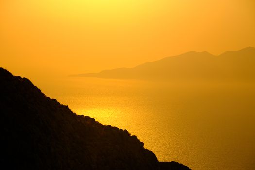 Landscape view of beautiful colorful sunrise above the ocean with horizon and distant islands, Santorini, Greece