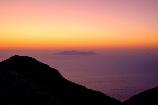 Landscape view of beautiful colorful sunrise above the ocean with horizon and distant islands, Santorini, Greece