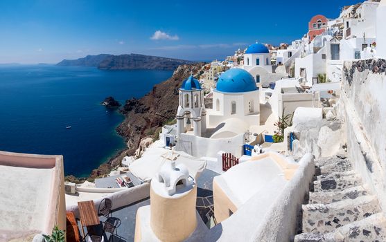 Panoramic scenic view of Oia village white houses and blue domes, Santorini island, Greece