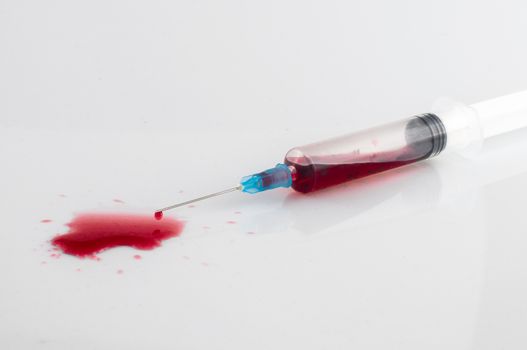 Syringe with blood on withe background