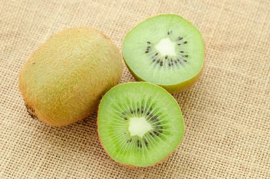 Fresh kiwi fruit and slic fruit put on sack background.