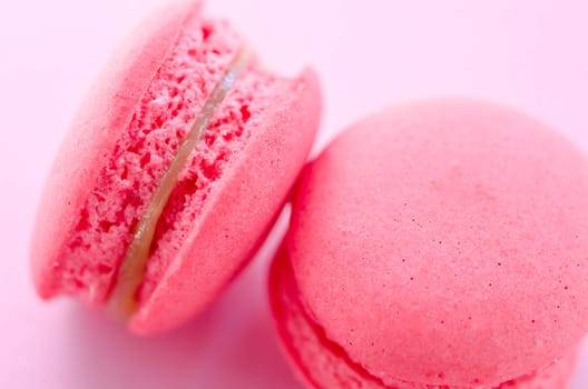 Top view of tasty pink macaroons on pink background.