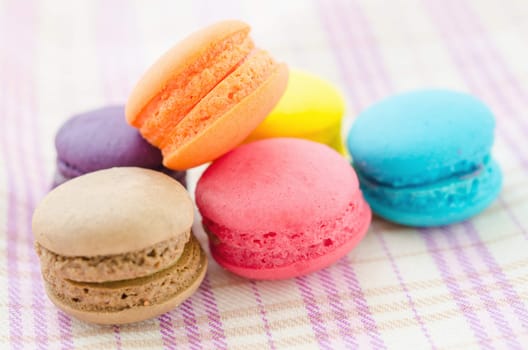 Colorful macaroons on tablecloth.
