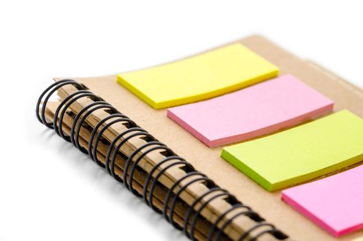 Close up note book with colorful note pad on white background.