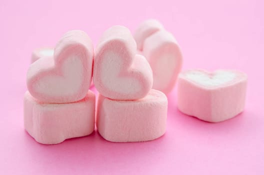 sweet heart shape of marshmallows on pink background.