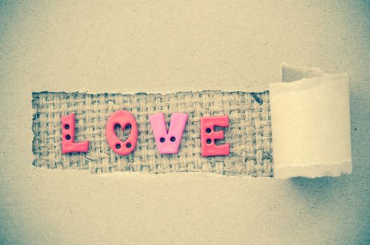 Grunge of love text on on brown paper background.