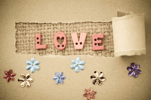Grunge of love text on on brown paper background.