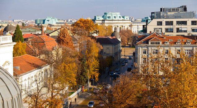 View of downtown Sofia with yellow stone paved central bulevard "Tsar Osvoboditel" and the Sofia University "St. Climent Ohridski"(with green roof) at the back and a part of the Bulgarian Academy of sciance in the center.