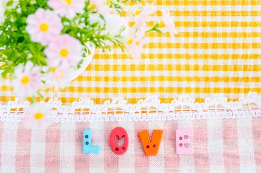 Love aphabet with flower on beautiful fabric background. Love concept.