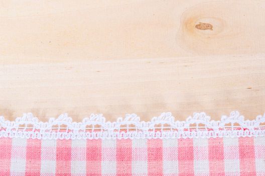 Table cloth and white lace on wooden texture or background.