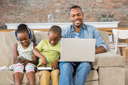 Happy family using technology together in living room