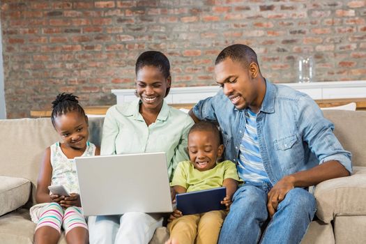 Happy family using technology together in living room