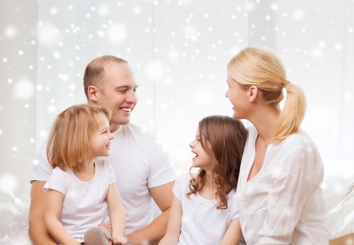 family, childhood, communication, people and home concept - smiling parents with two little girls talking at home