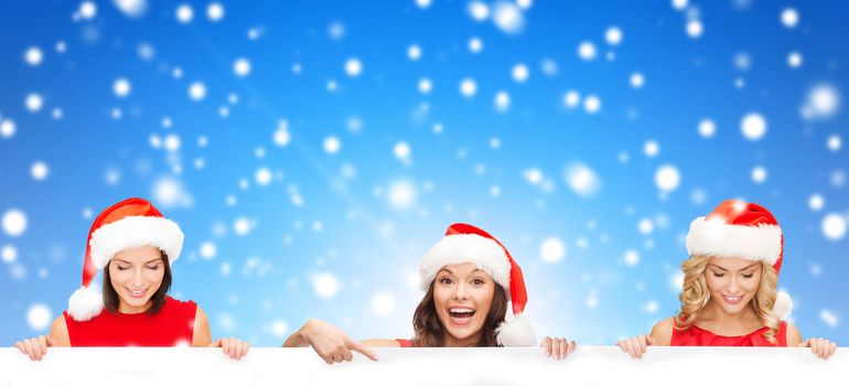 christmas, x-mas, people, advertisement and sale concept - happy women in santa helper hat with blank white board over blue snowy background