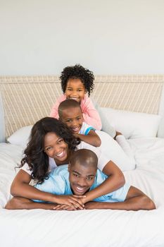 Family having fun together in bed in a pile
