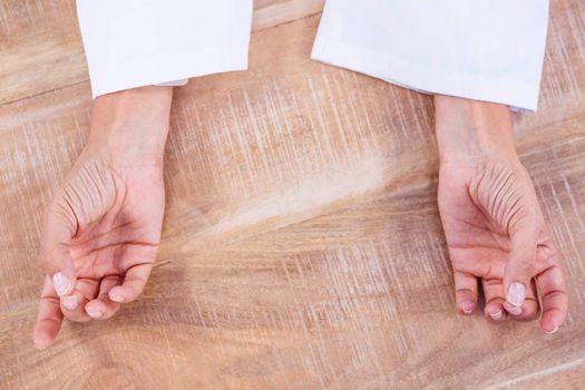 Close up view of hands in yoga pose on wood desk