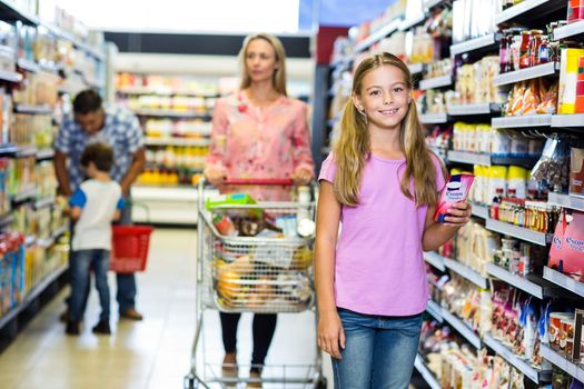 Smiling child with her family in the supermarket