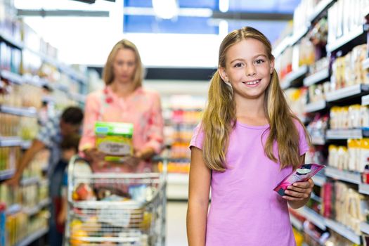 Smiling child with her family in the supermarket