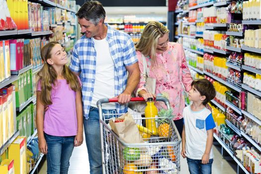 Happy family at the supermarket with cart