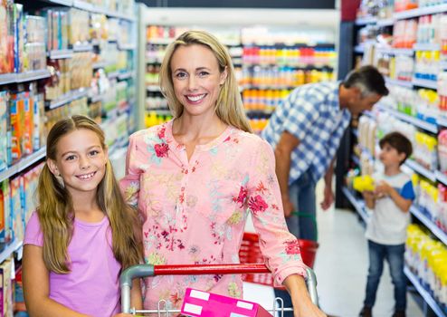 Happy family at the supermarket with cart