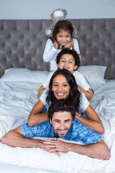 Happy family on the bed posing for camera