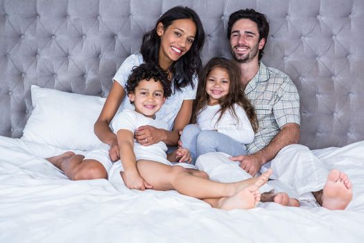 Happy family on the bed posing for camera