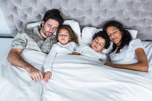 Family sleeping together in bed 