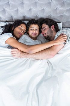 Family sleeping together in bed 