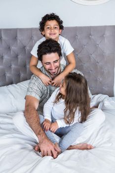 Happy family on bed posing for camera