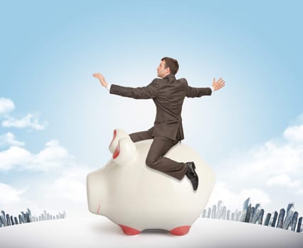 Businessman sitting on piggy bank on nature background