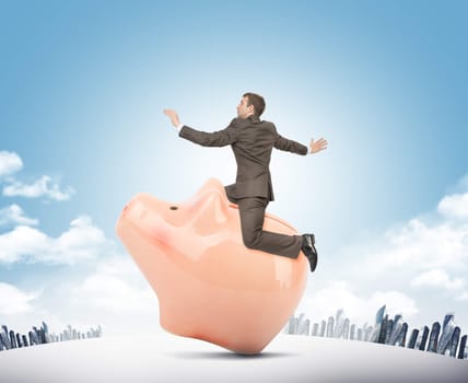 Businessman sitting on piggy bank on nature background